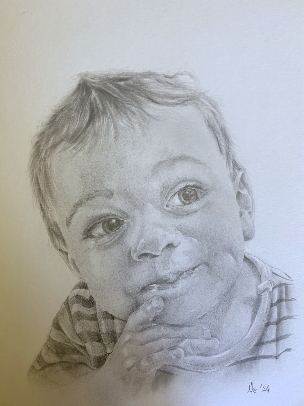 Pencil portrait of a smiling baby resting his chin on his hand, wearing a striped shirt.