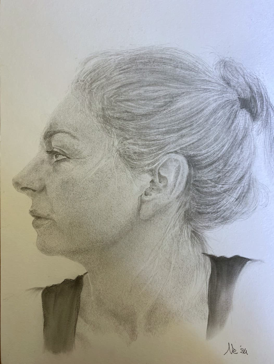 Pencil profile portrait of a woman with her hair in a bun.