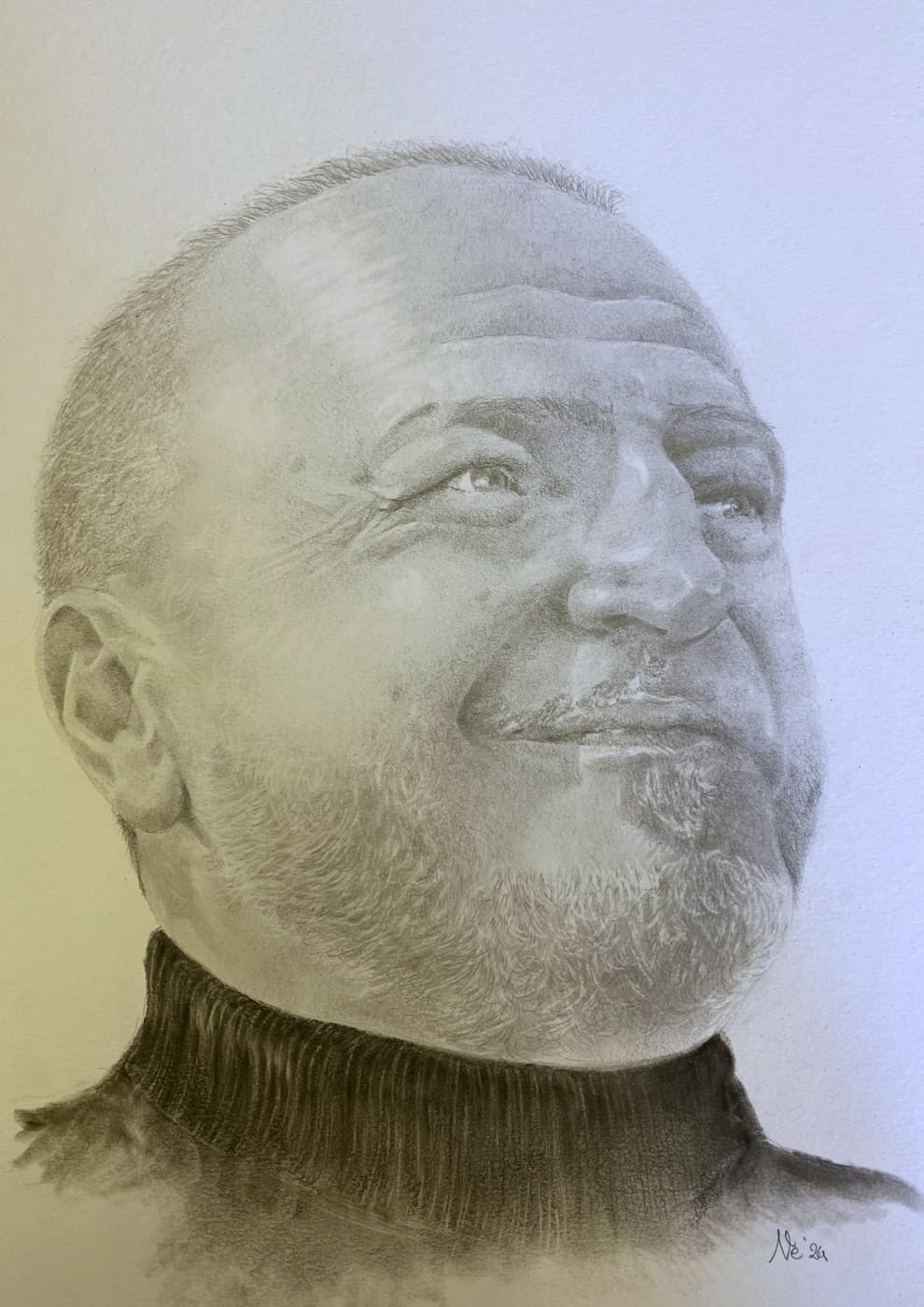 Pencil portrait of a bald, bearded man in a turtleneck, smiling upward.