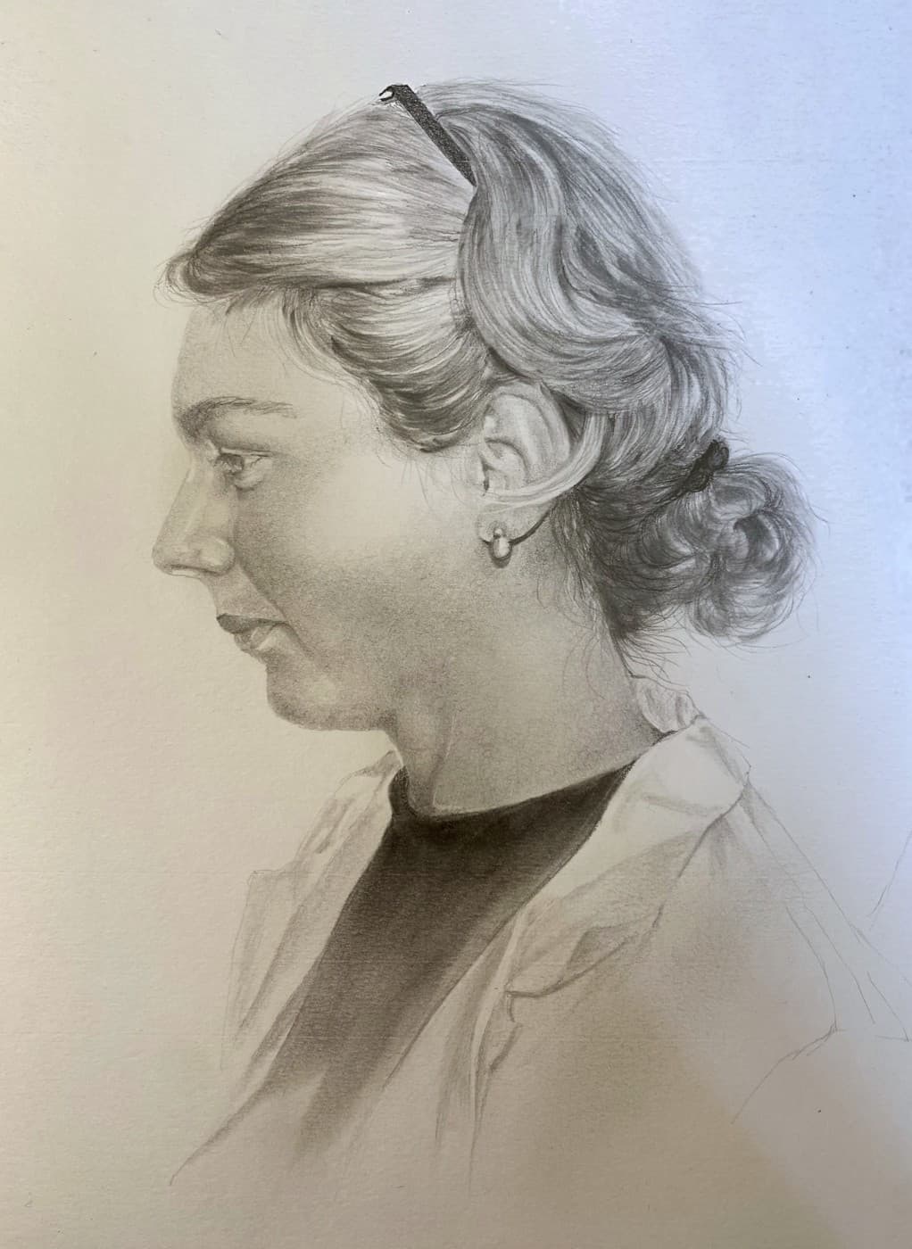 Pencil profile portrait of a woman with a headband and her hair tied back.