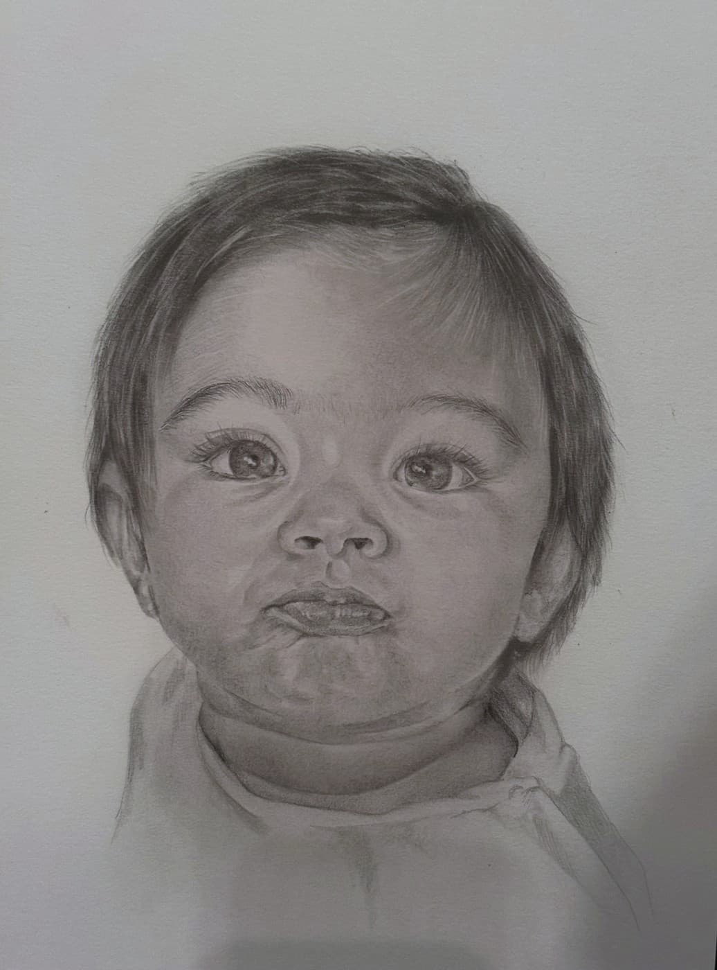 Pencil portrait of a wide-eyed toddler.